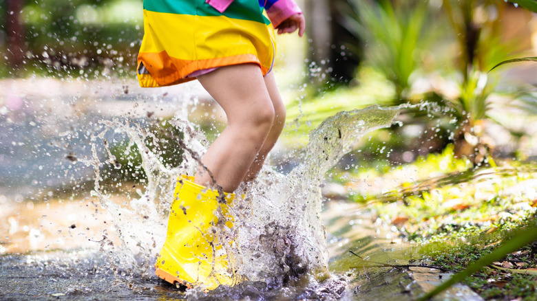 Child boots splashing in water