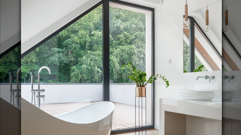 bathtub next to floor-to-ceiling windows