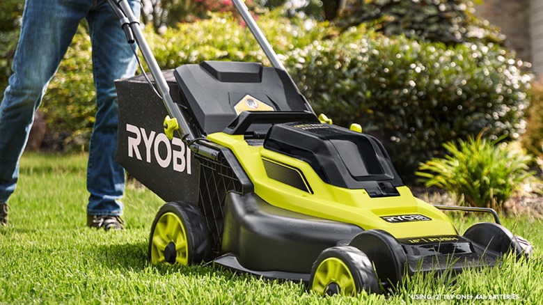 A man pushing an 18V Ryobi lawn mower