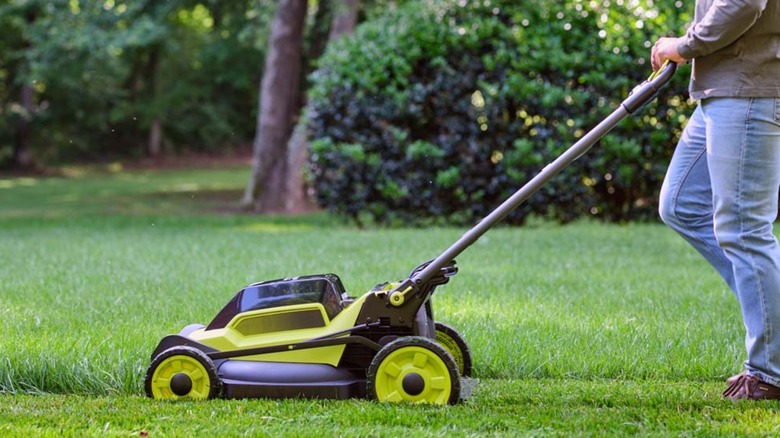 A man pushign a 40V Ryobi lawn mower