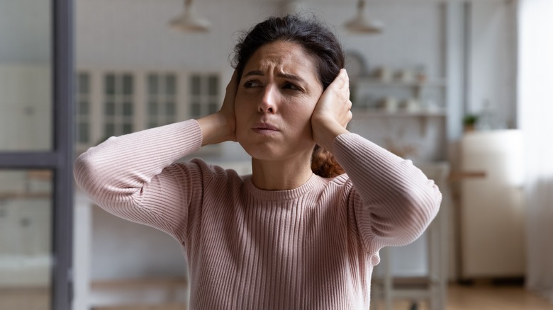 person holding their ears