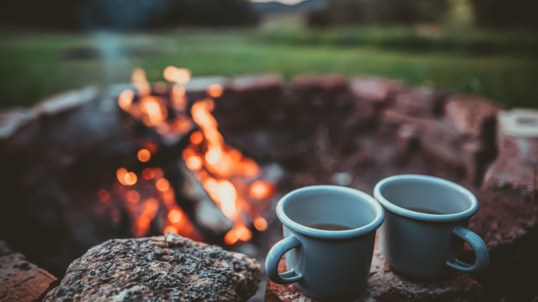 Two mugs by bonfire 