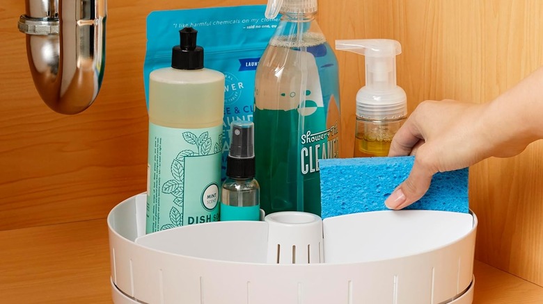 A lazy Susan organizer under the sink with cleaning supplies