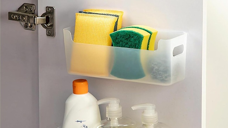 Two storage caddies with cleaning supplies inside a cabinet door