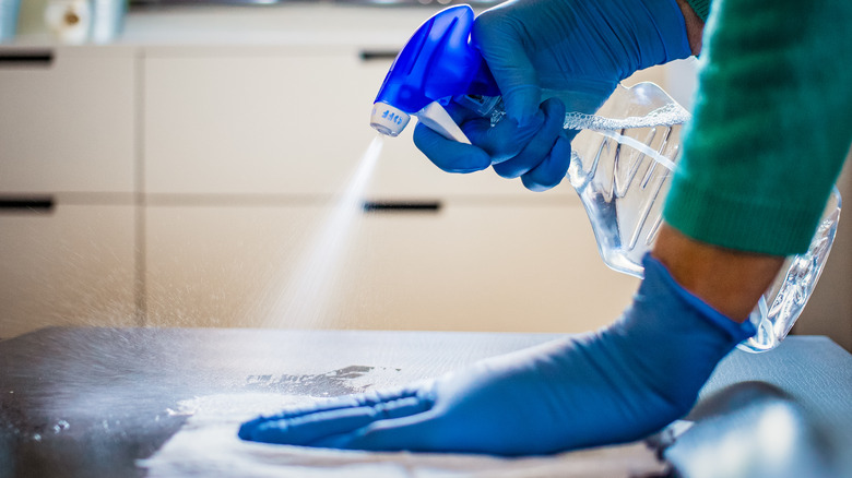 woman disinfecting a countertop