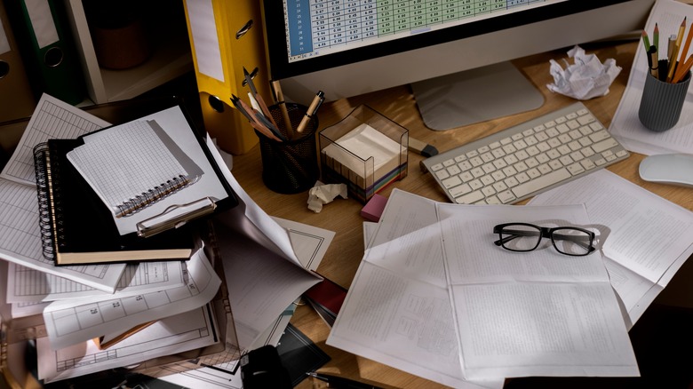 cluttered desk with office supplies