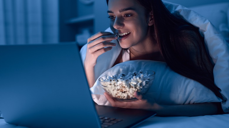 woman snacking in bed