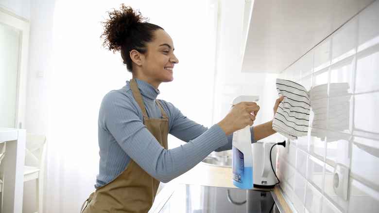 woman cleaning kitchen backsplash