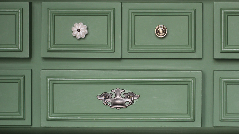 Mismatched knobs on green drawers