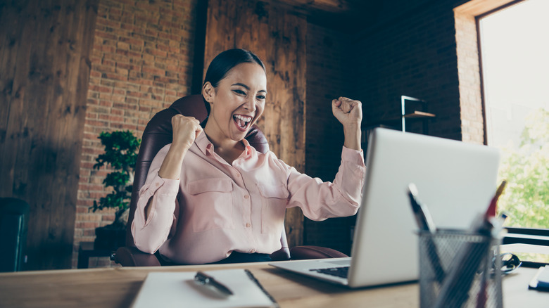 Woman celebrating at computer