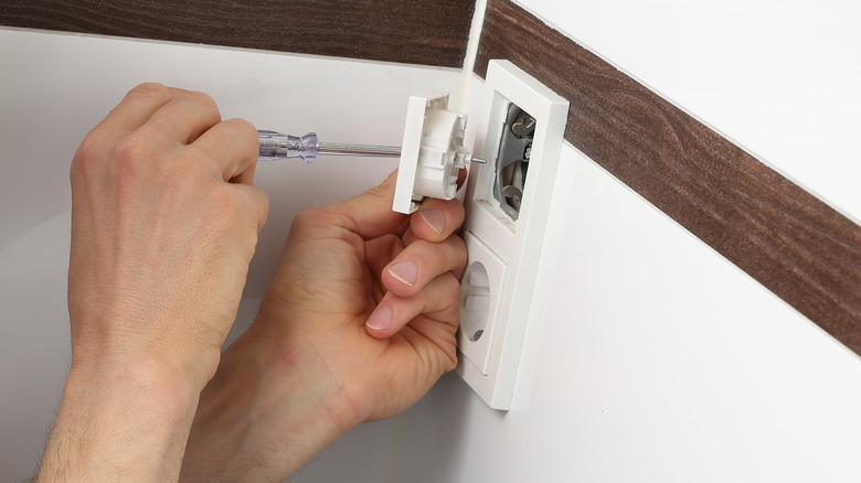 man fixing outlet in bathroom