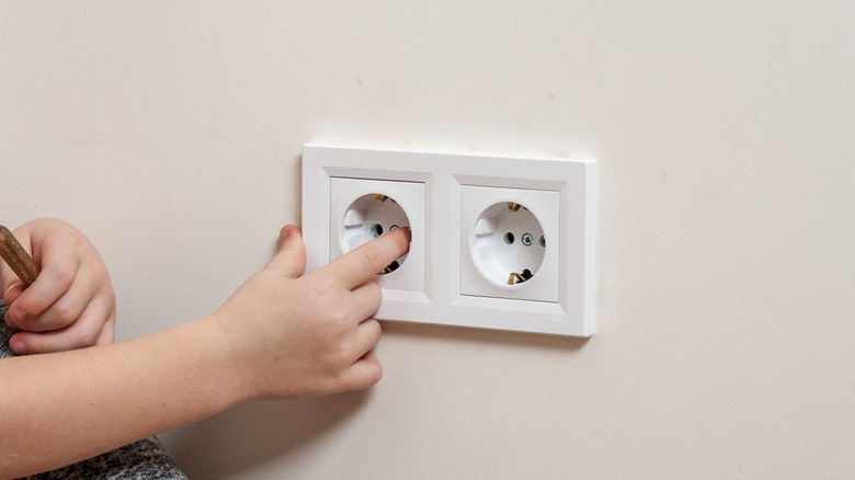 child playing with electrical outlet