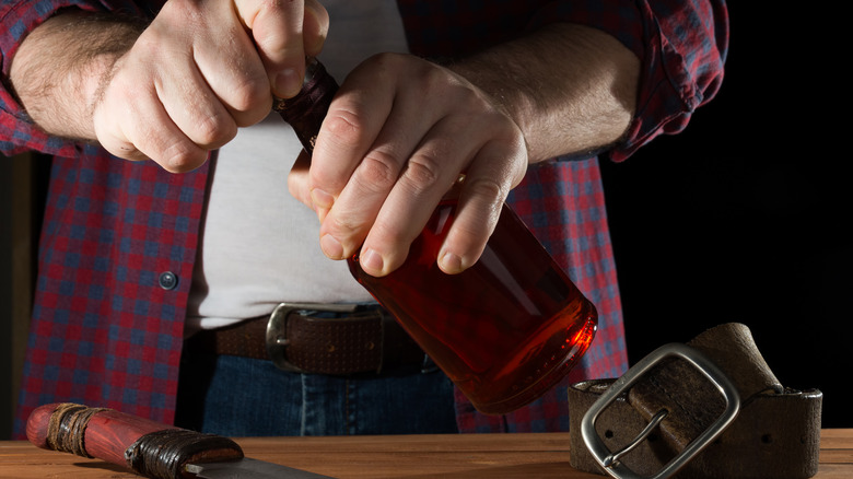 opening bottle with belt on table