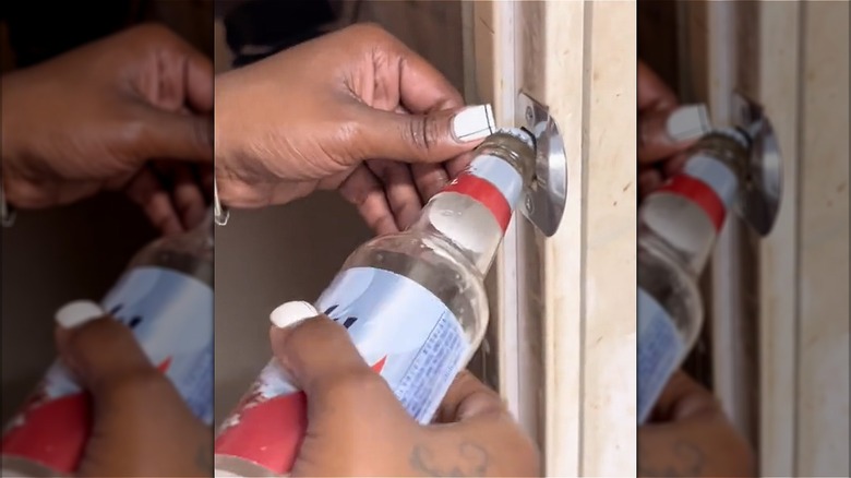 hands opening bottle with door