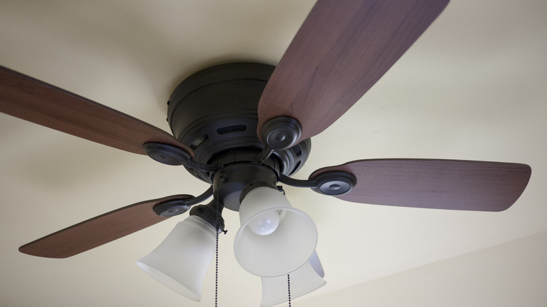 Close up of an old ceiling fan with wooden blades