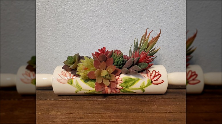 Painted and glazed white rolling in with fake plants in it