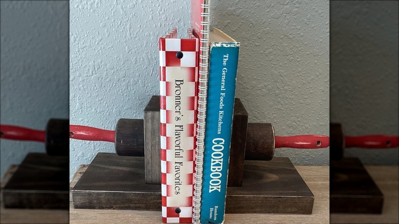 Rolling pin cut in half and used as bookends for cookbooks