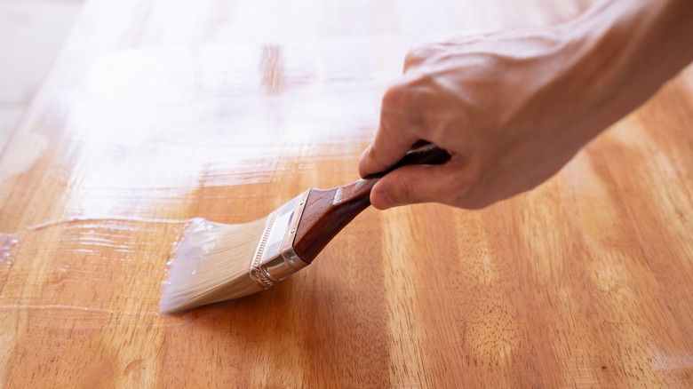 A person applying stain to the floor