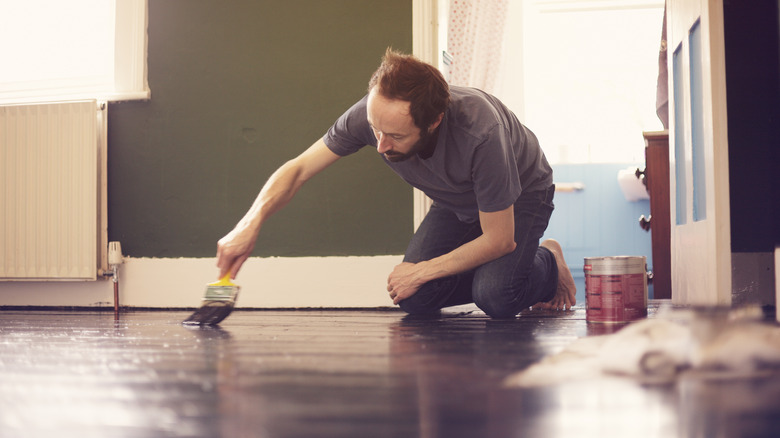 A man painting the floor