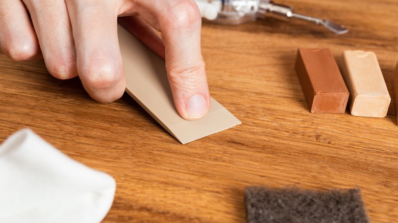 A person working to repair flooring