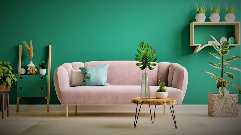 Pink couch against green wall