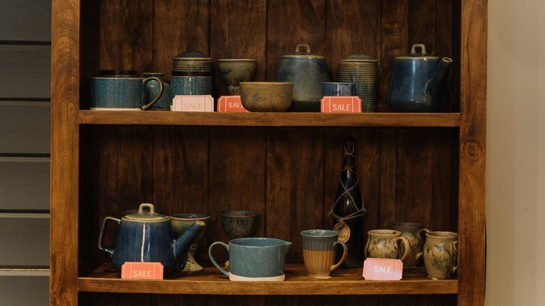 ceramic mugs on brown shelf