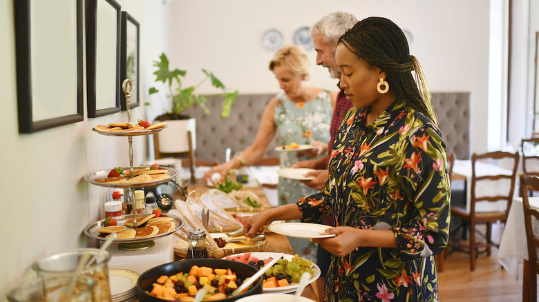 People helping themselves to food at a buffet setup