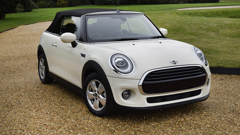 A Mini Cooper parked on a gravel driveway