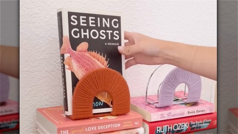 hand putting book in holder