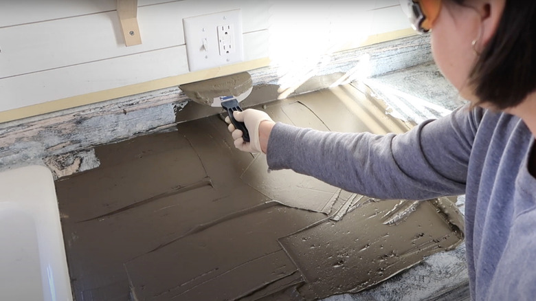 woman skim painting countertop with concrete