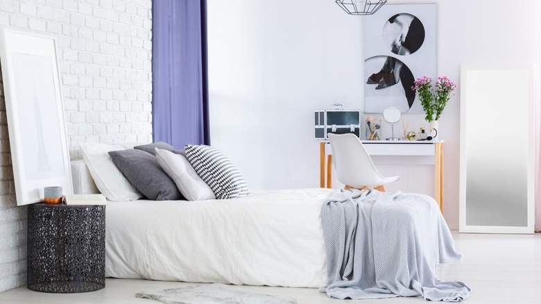 White bedroom with periwinkle curtain