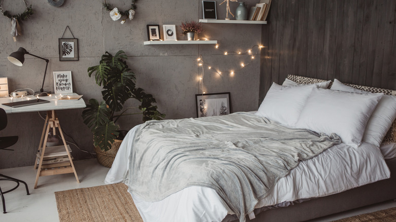 Neutral colored bedroom with plants, a rug, and other decor