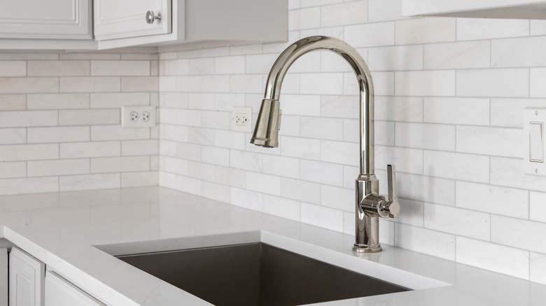 A kitchen with a white tile backsplash