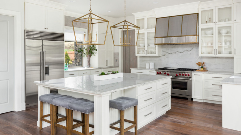 A kitchen with large pendant lights over the island