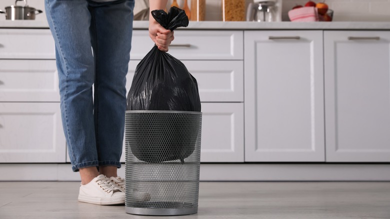 person taking out kitchen trash