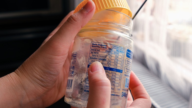 person holding empty peanut butter jar