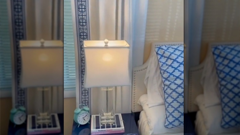 White curtain with blue geometric trim behind lamp