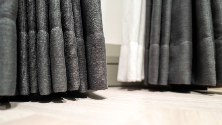 Hem of gray and white curtains that are almost touching the floor