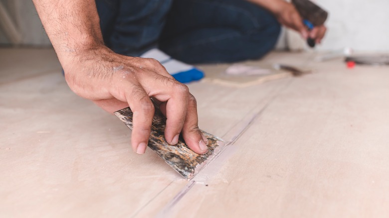 Person preparing subfloor