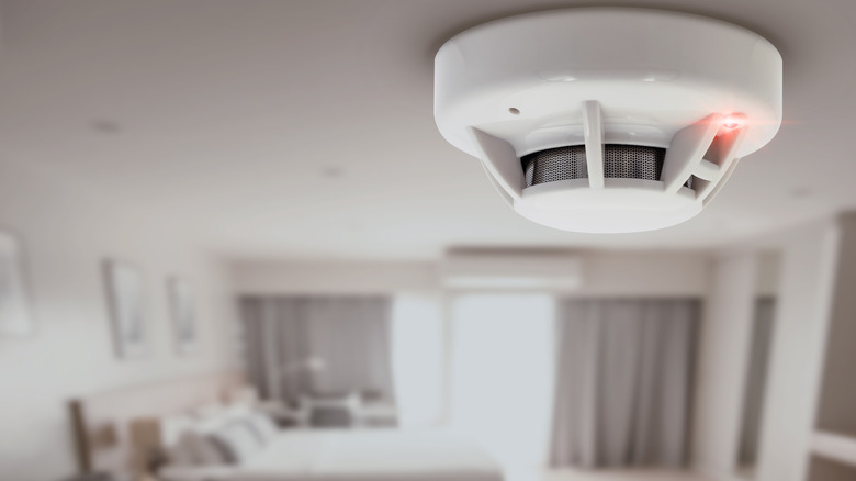 Smoke detector device set up on ceiling in a studio apartment