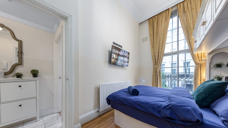 White bedroom with pale yellow curtains.