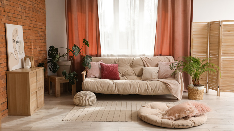 White living room with terracotta drapes.