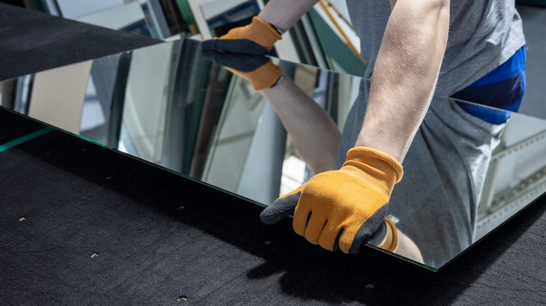 person holding mirror panel