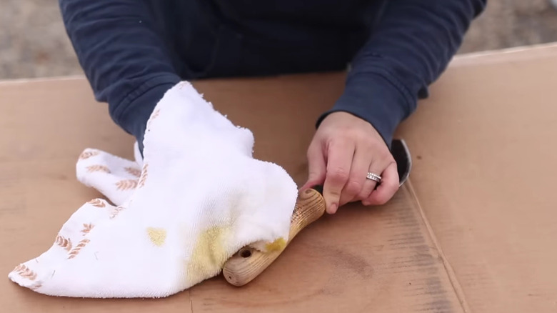 woman cleaning hand trowel with old towel