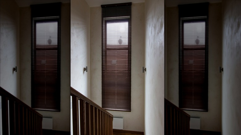 Wooden blinds on narrow window in hallway