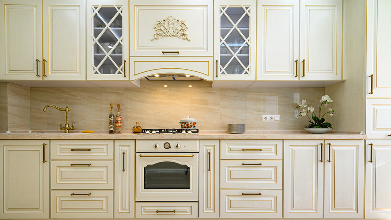 A kitchen with off-white cabinets and white appliances