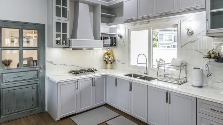 Light gray cabinets with white counters and backsplash