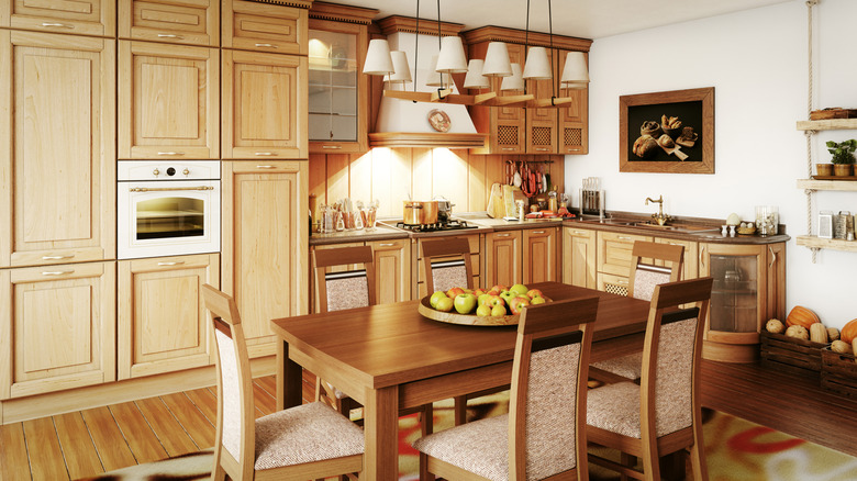 A kitchen with light wood cabinets with a white oven