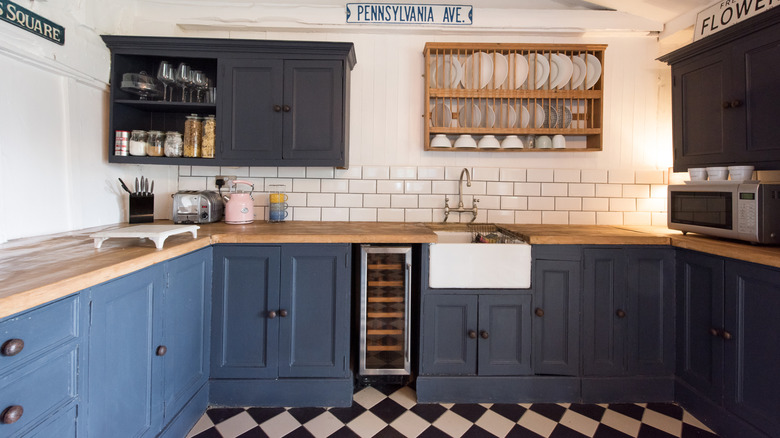 Dark navy blue kitchen cabinets with wood countertops