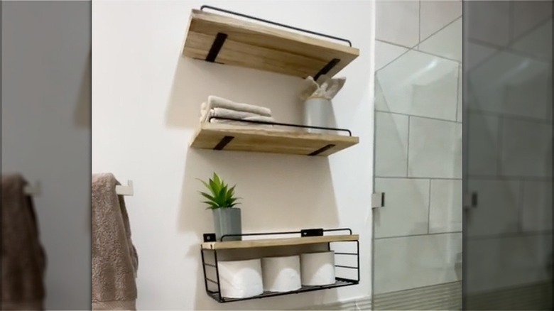 Assorted floating shelves installed above a toilet in the bathroom